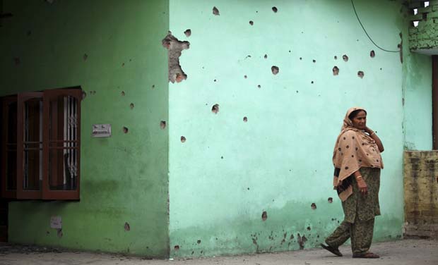 A woman stands next to mortar shell marks on the wall of her residence in Devigarh Village in Arnia Sector near the India-Pakistan border, 45 kilometers from Jammu (Photo: AP) A woman stands next to mortar shell marks on the wall of her residence in Devigarh Village in Arnia Sector near the India-Pakistan border, 45 kilometers from Jammu (Photo: AP)